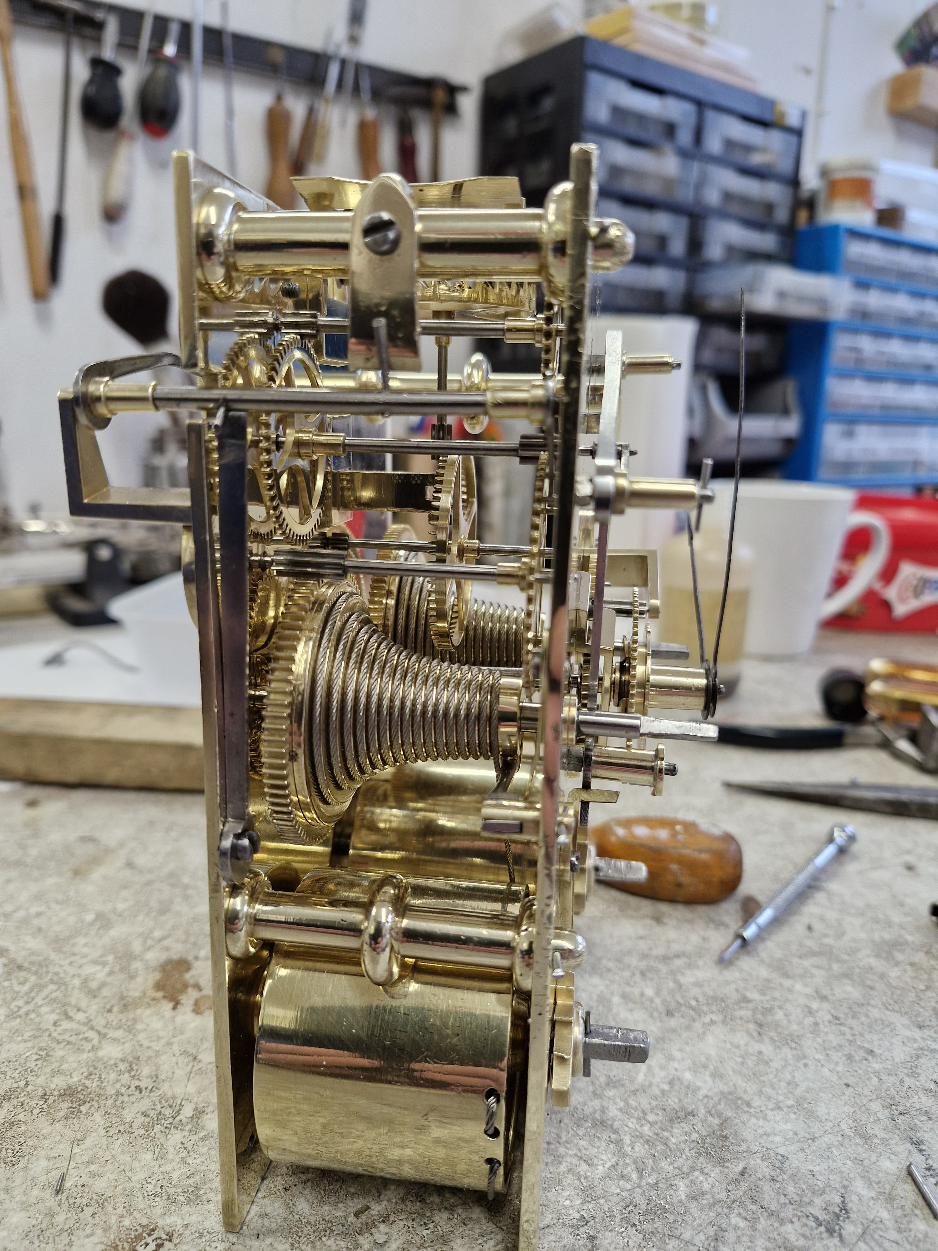 This image shows the movement restoration of an antique clock in a workshop